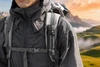 Olightの黒いOclip Proミニライトを登山のバックパックのショルダーストラップに装着し、大自然の中でハイキングやアウトドア、防災用として使用するシーン