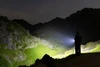 夜間の山岳地帯で強力な光を放つOlight Oclip Proクリップライトを使用し広範囲を明るく照らすハイキングシーン