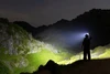 Olight Oclip Proを帽子に装着した男性が夜間の暗い山道を強力なライトで照らすクリップライトのアウトドア・登山での使用シーン