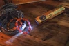 Olight ArkProのビンテージ風デザインEDCライトがウッドテーブル上でUV光を照射しパワーストーンブレスレットを照らす様子