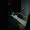 技術者がサーバー室でペンライト付きのペンでメモをとる様子