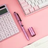ピンクの背景にドーナツ模様のペン、電卓、ピンクのキーボード