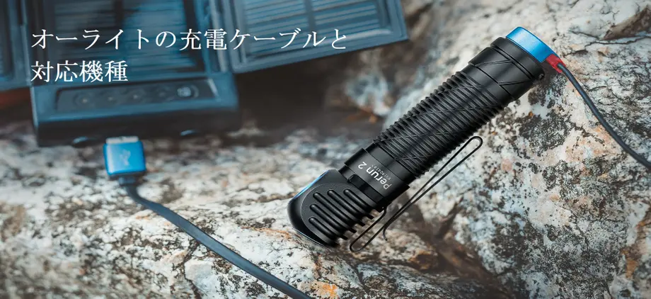 オーライトの懐中電灯と充電ケーブルが岩の上に置かれたアウトドアシーン。