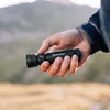 OlightブラックSeeker 4 Pro懐中電灯、ハイキングやアウトドアでの信頼できる照明として手に持っています。