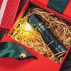 赤いギフトボックスに入ったOlightの懐中電灯、光るワット、クリスマスリボン、ギフトラッピング