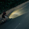 夜道を自転車で走るサイクリスト、前方を照らす明るいライト