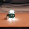Olightの小型LEDランタンが木製テーブルで光る、キャンプ用品