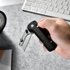 Olight U1 Pro ブラックカーボンの折りたたみ式ユーティリティナイフを片手で持っている様子、デスクワークや日常使いに最適。