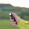 山を背景に、手でヘッドライトのボタンを押している男性