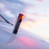 Perun 3懐中電灯と赤い光が白い表面に反射し、空の光る背景が映し出されています