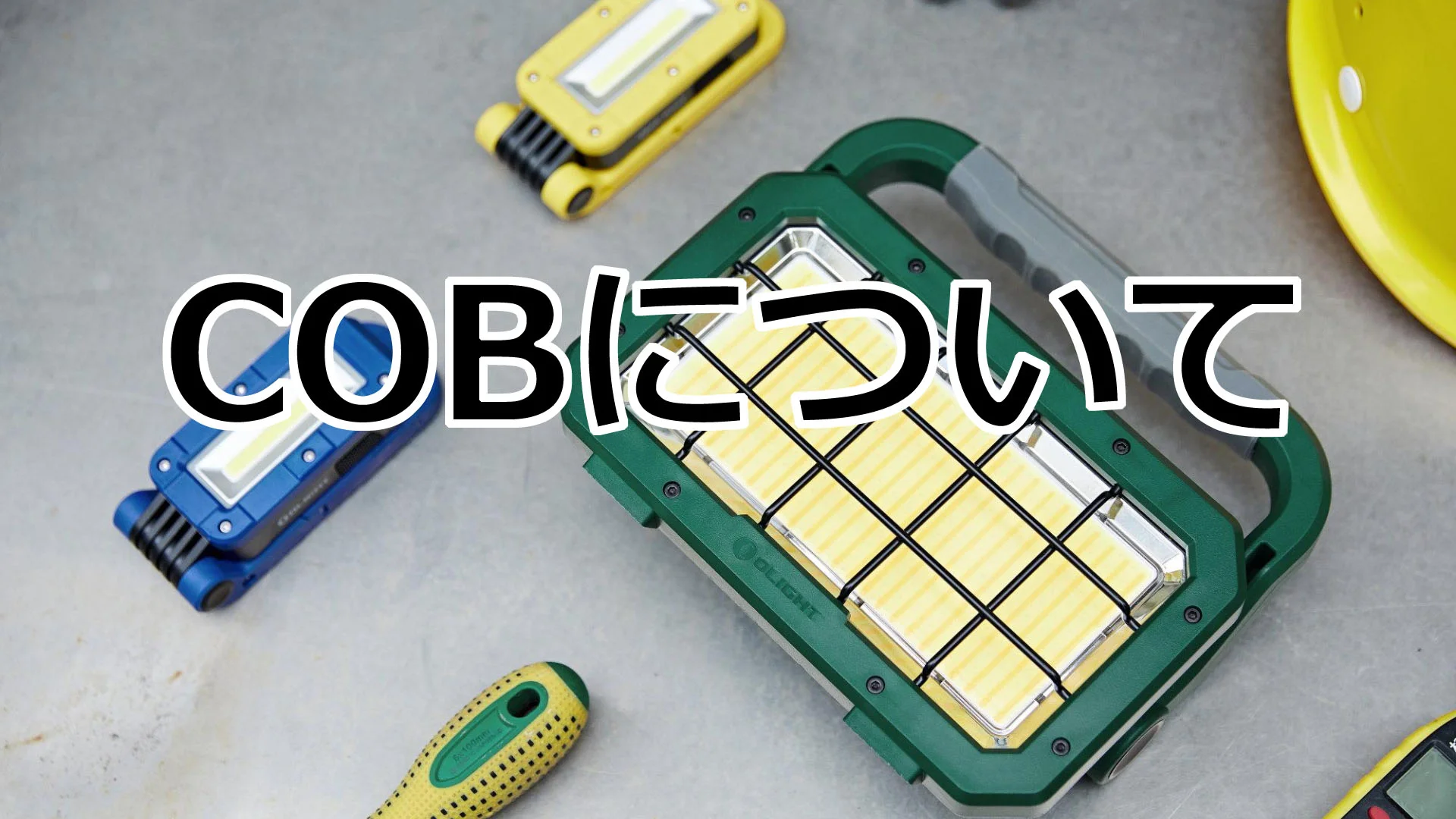 緑色と青色のCOBライト、黄色のヘルメット、工具が並ぶ作業現場の写真
