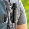 Olightの懐中電灯をバックパックに引っ掛ける男性