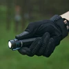 戦術手袋をはめて懐中電灯を持つ手